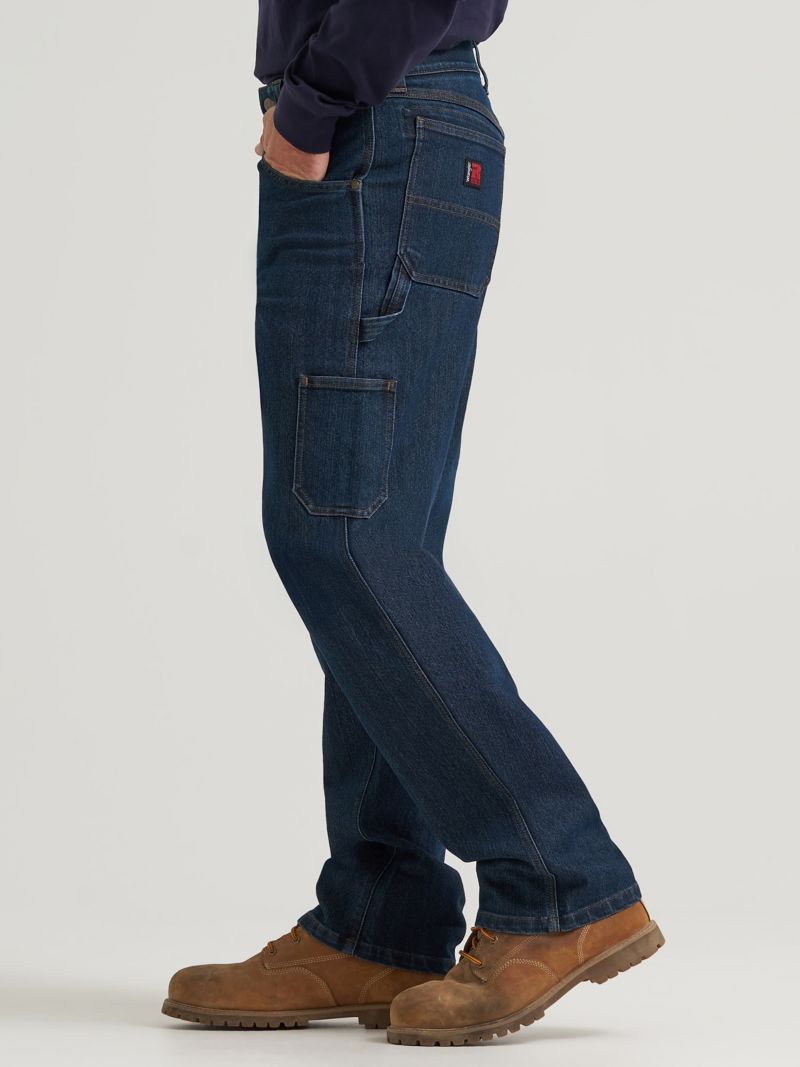 Dark denim carpenter jeans showing side utility pockets and a hammer loop